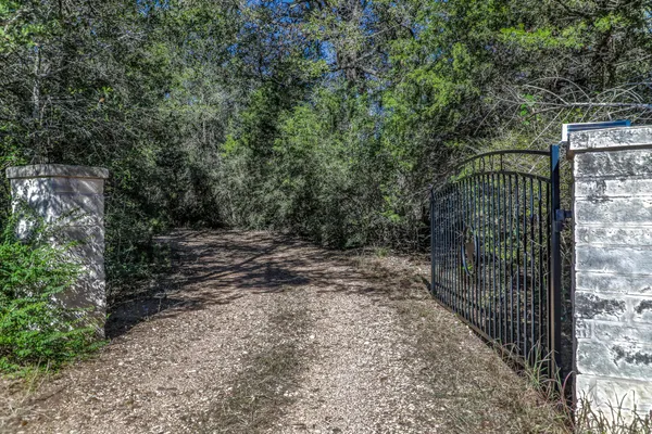a view of a pathway of a building with large trees