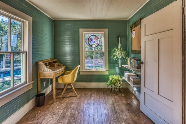 a dining room with wooden floor and white walls