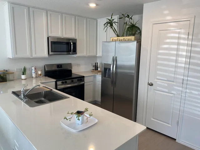 a kitchen with stainless steel appliances a refrigerator a sink a stove and cabinets