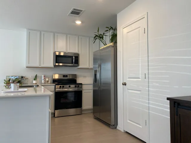 a kitchen with stainless steel appliances granite countertop a refrigerator a stove a sink and a granite counter tops