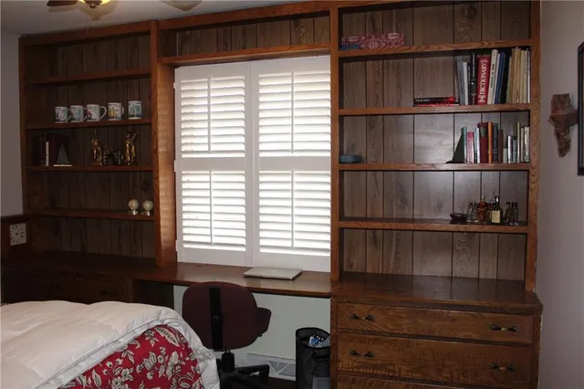 a bedroom with a bed and a book shelf