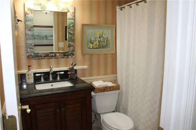 a bathroom with a granite countertop sink toilet and shower