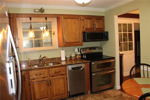 a kitchen with stainless steel appliances granite countertop a stove a sink and a microwave