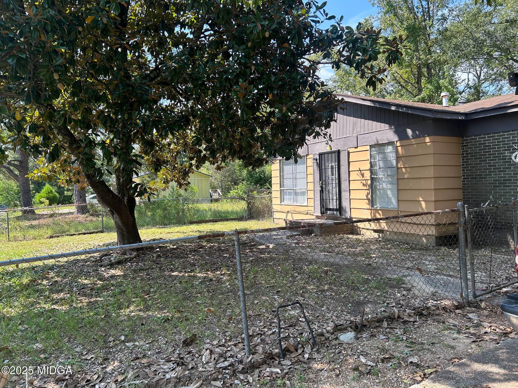 a view of a house with backyard and a tree