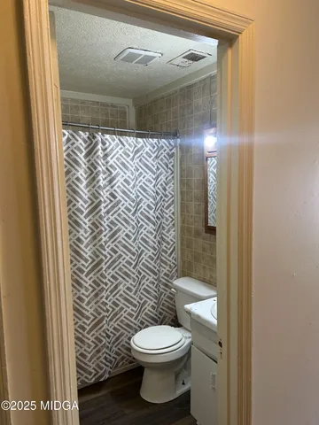 a bathroom with a toilet and a shower curtain