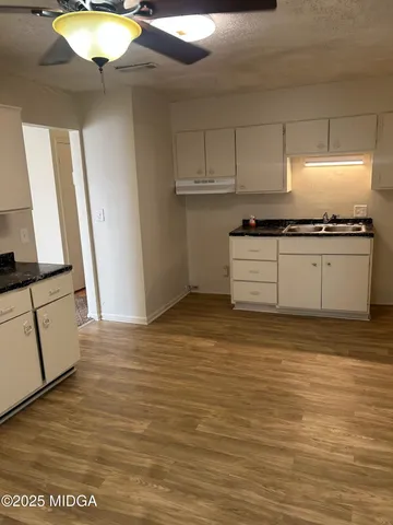 a kitchen with stainless steel appliances granite countertop a stove a sink and a microwave