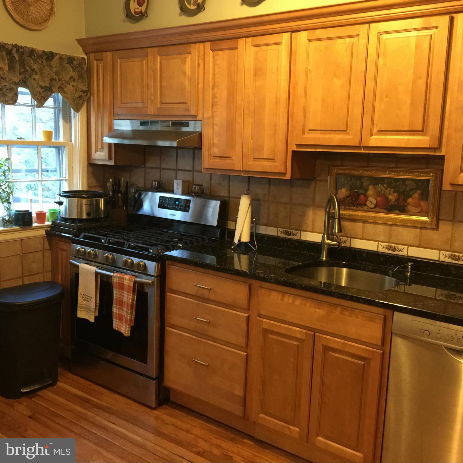305 Westowne Road Baltimore, MD 21229 - Photo 4 of 30 a kitchen with granite countertop a stove sink and cabinets