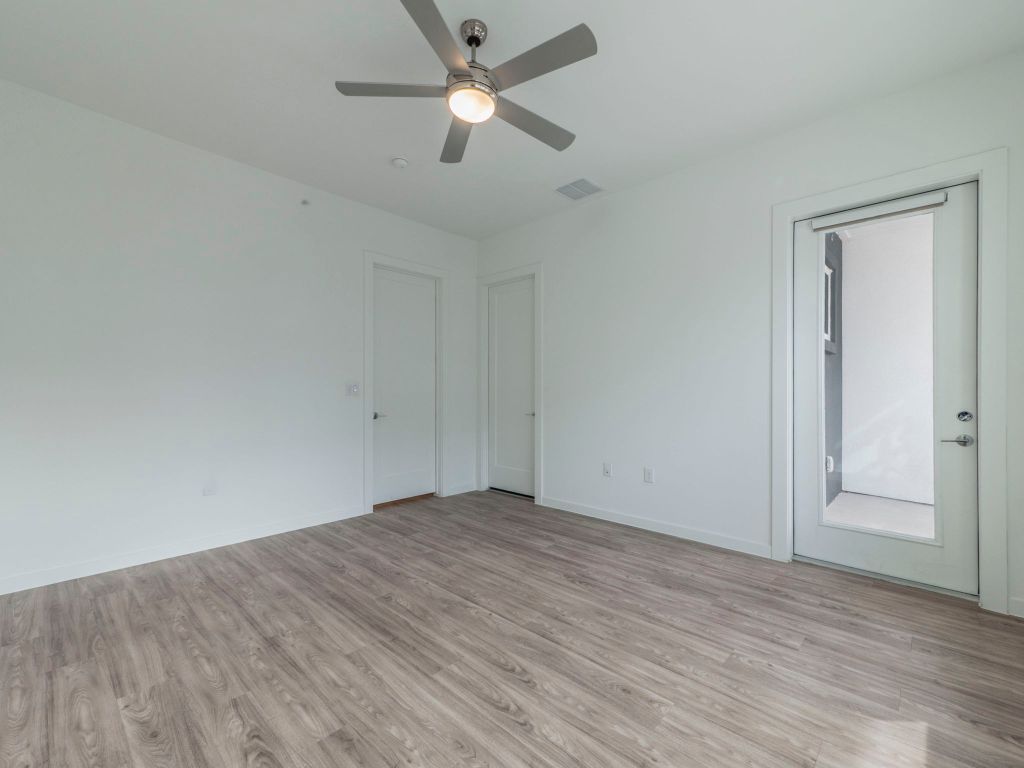 4901 Springdale Road, Unit 103 Austin, TX 78723 - Photo 15 of 26 an empty room with wooden floor and a ceiling fan