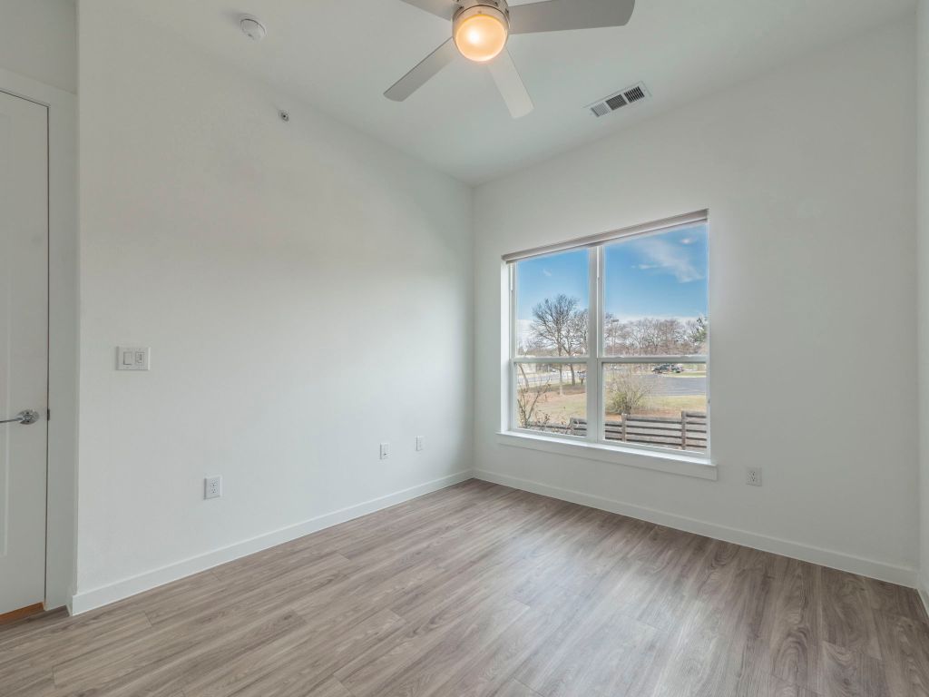 4901 Springdale Road, Unit 103 Austin, TX 78723 - Photo 21 of 26 an empty room with wooden floor and windows
