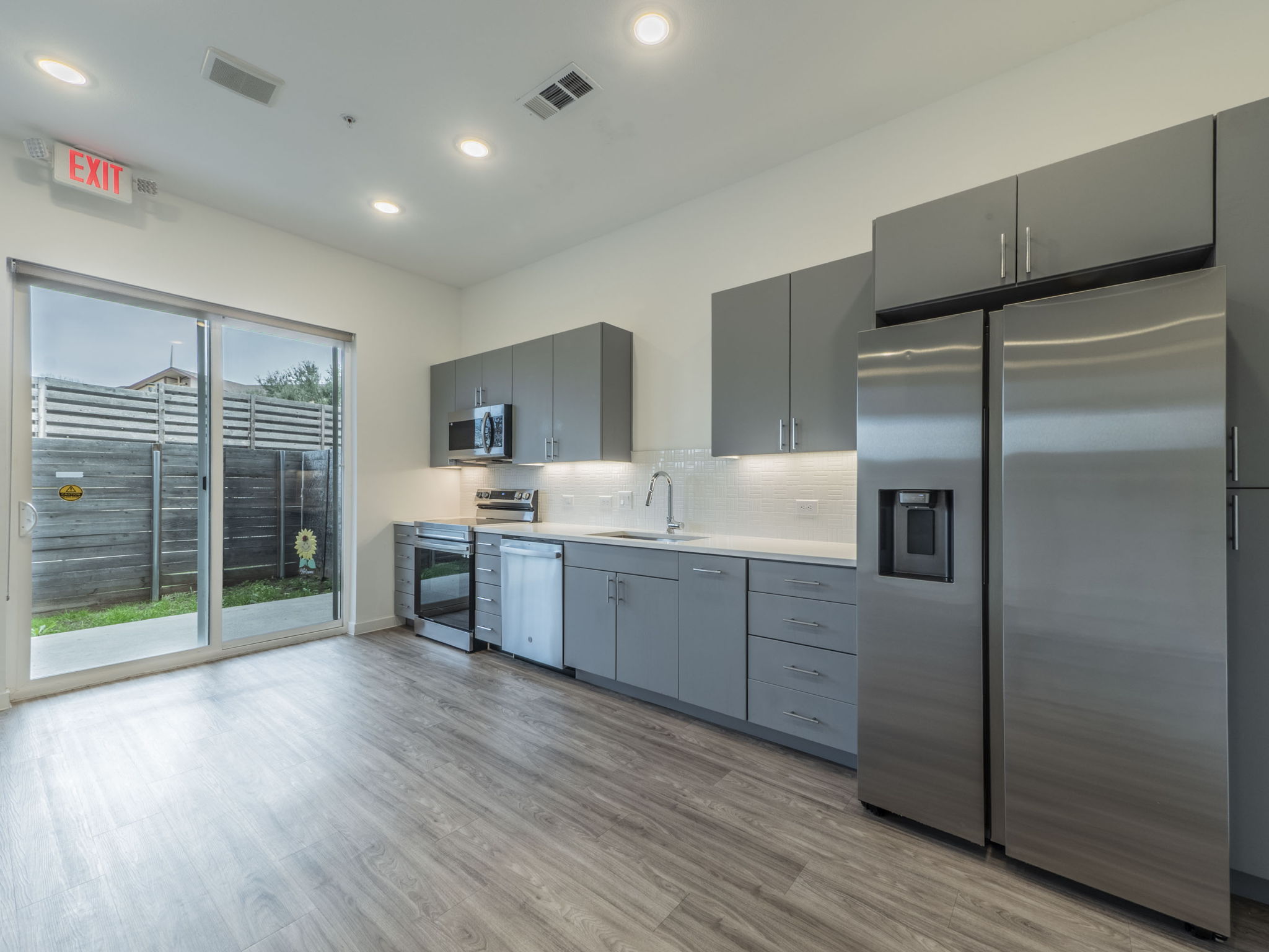 4901 Springdale Road, Unit 103 Austin, TX 78723 - Photo 5 of 26 a kitchen with stainless steel appliances a refrigerator sink and wooden cabinets