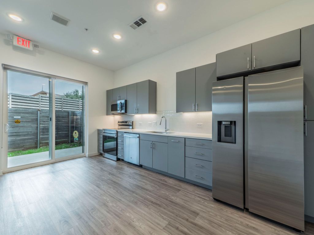 4901 Springdale Road, Unit 103 Austin, TX 78723 - Photo 5 of 26 a kitchen with stainless steel appliances a refrigerator sink and wooden cabinets