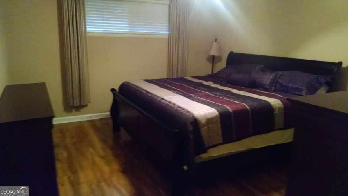 250 Little Street, Unit A301 Athens, GA 30605 - Photo 11 of 15 a bedroom with a bed and wooden floor