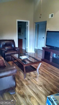 a living room with couch chairs and a piano