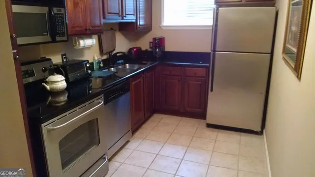 a kitchen with a refrigerator sink and cabinets