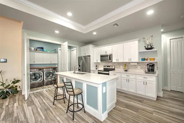 a kitchen with white cabinets appliances and cabinets