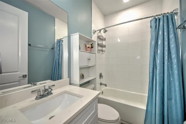 a bathroom with a bathtub shower sink vanity and toilet