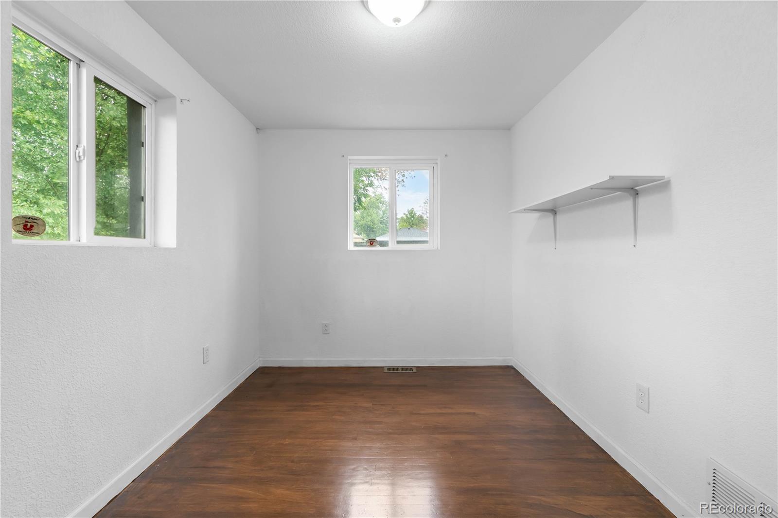 7010 West 44th Avenue Wheat Ridge, CO 80033 - Photo 24 of 31 an empty room with wooden floor and windows