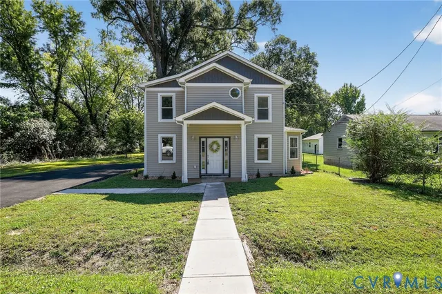 a front view of a house with yard and green space
