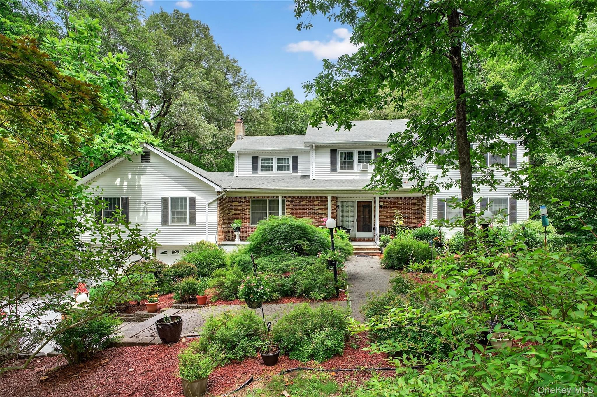 a front view of a house with a yard and trees