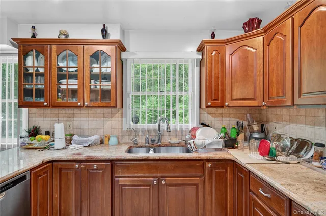 a kitchen with stainless steel appliances wooden cabinets a sink and a window