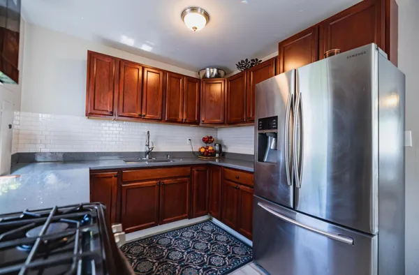 a kitchen with stainless steel appliances granite countertop a refrigerator a sink dishwasher a stove and a microwave oven