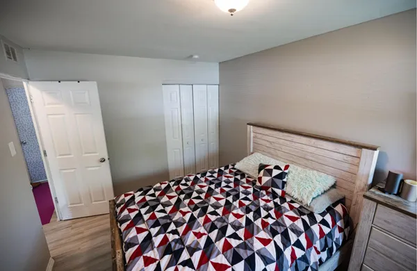 a bedroom with a bed and wooden floor