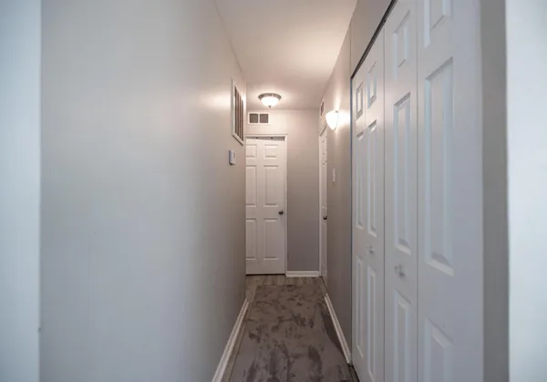 a view of a hallway with wooden floor