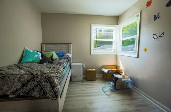 a bedroom with a bed and wooden floor