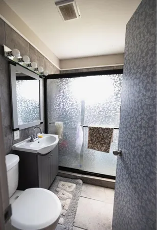 a bathroom with a sink toilet and window