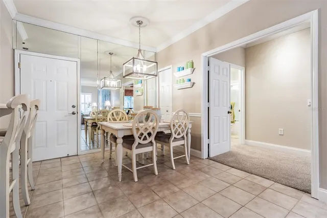a dining room with furniture a chandelier and kitchen view