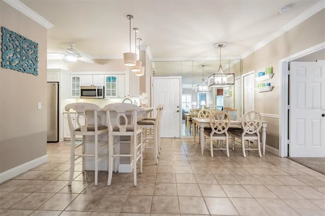 a dining room with furniture a chandelier and kitchen view