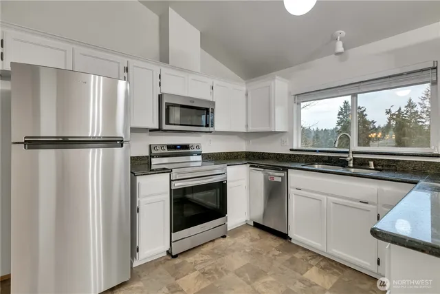 a kitchen with cabinets stainless steel appliances and window