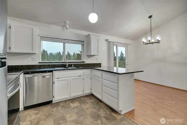 a kitchen with granite countertop white cabinets and white appliances