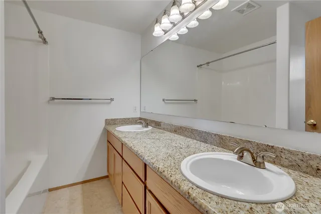 a bathroom with a granite countertop sink a mirror and vanity