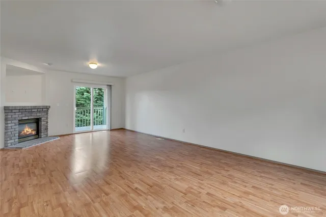 a view of empty room with wooden floor and fireplace
