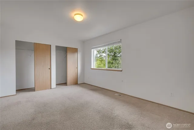 an empty room with windows and closet