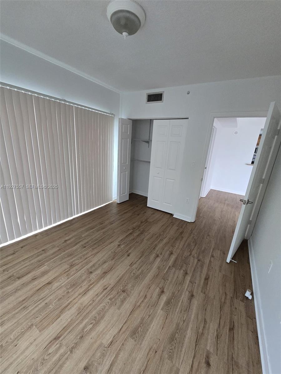 4242 Northwest 2nd Street, Unit 1614 Miami, FL 33126 - Photo 13 of 24 an empty room with wooden floor and windows