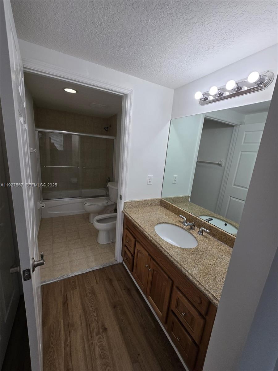 4242 Northwest 2nd Street, Unit 1614 Miami, FL 33126 - Photo 17 of 24 a bathroom with a granite countertop sink a toilet and a mirror