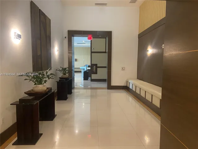 a hallway with a large mirror and couches in a room