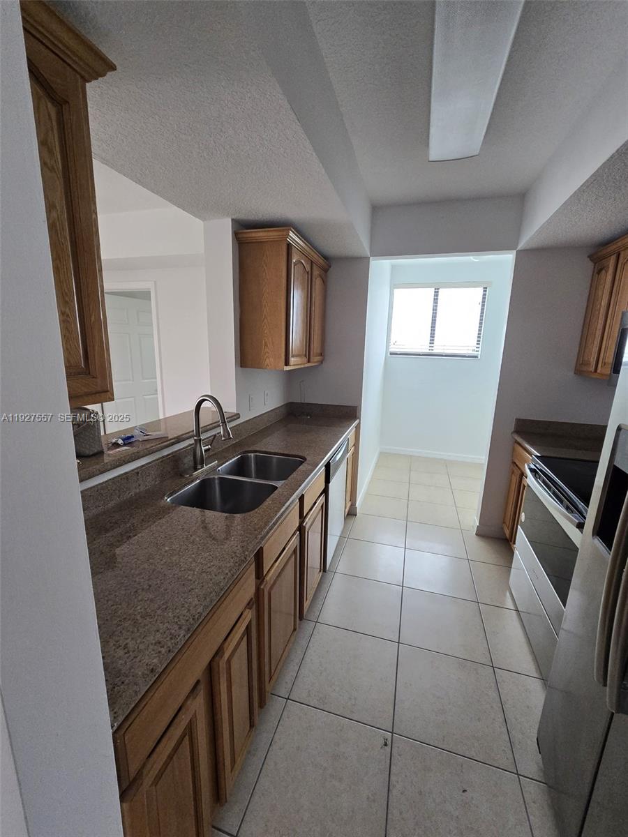 4242 Northwest 2nd Street, Unit 1614 Miami, FL 33126 - Photo 9 of 24 a kitchen that has a sink a stove top oven a counter space and cabinets