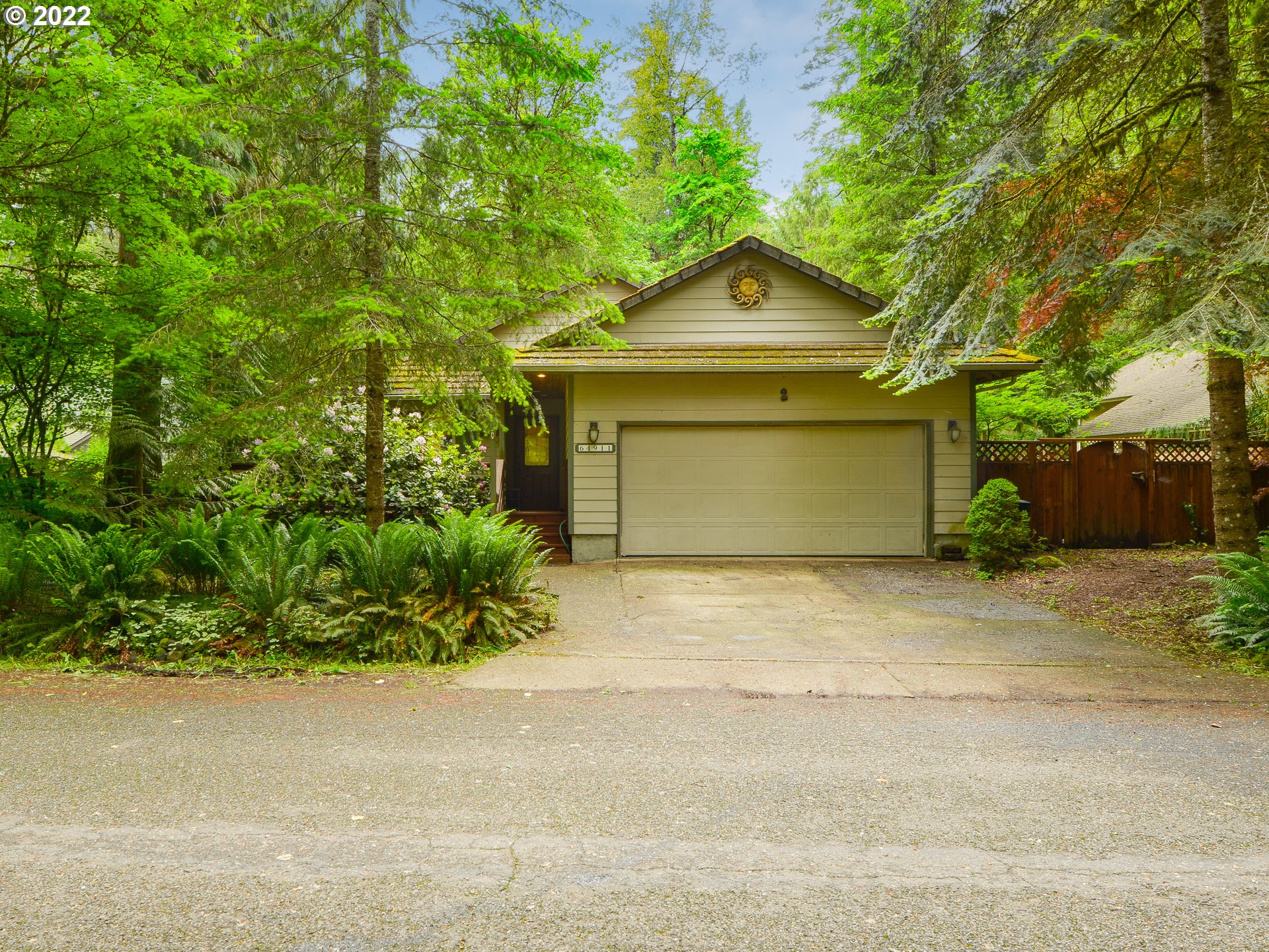 64911 East Sandy River Lane Rhododendron, OR 97049 - Photo 1 of 27 a front view of a house with a yard and garage
