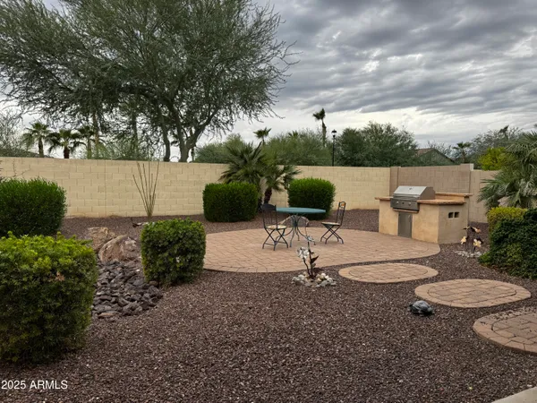 a view of a backyard with table and chairs plants and trees