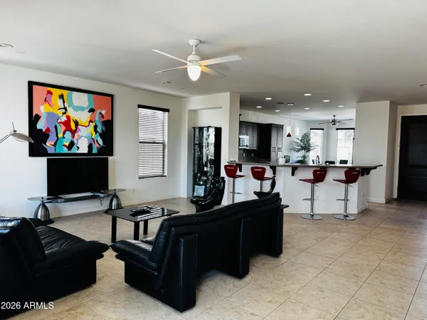 a living room with furniture kitchen view and a flat screen tv