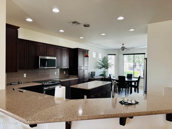 a kitchen with stainless steel appliances kitchen island granite countertop a refrigerator and stove
