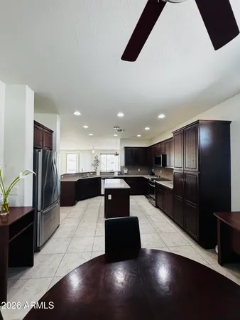 a large kitchen with stainless steel appliances kitchen island a large counter top a stove a refrigerator and a sink