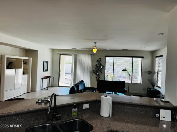 a living room with furniture a large window and wooden floor