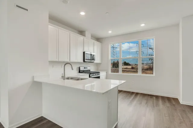 a kitchen with a sink wooden floor and a window
