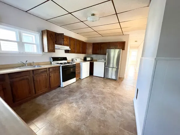 a kitchen with stainless steel appliances granite countertop a stove a sink dishwasher a refrigerator and a microwave oven