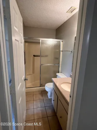 a bathroom with a granite countertop sink a toilet and shower