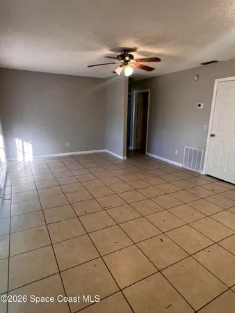 a view of a livingroom and a chandelier fan and windows